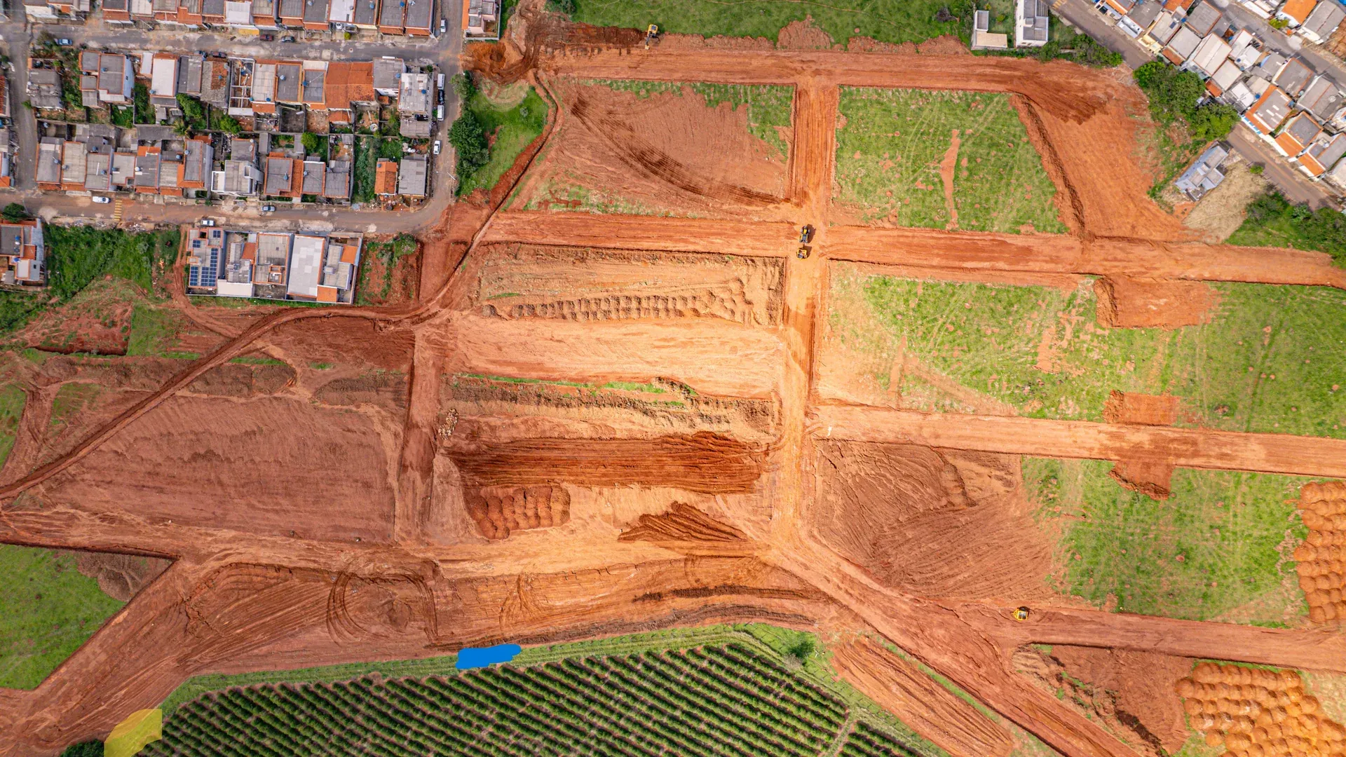 Aérea do Ouro Verde com o entorno verde — lavouras e mata — cercando o loteamento em implantação