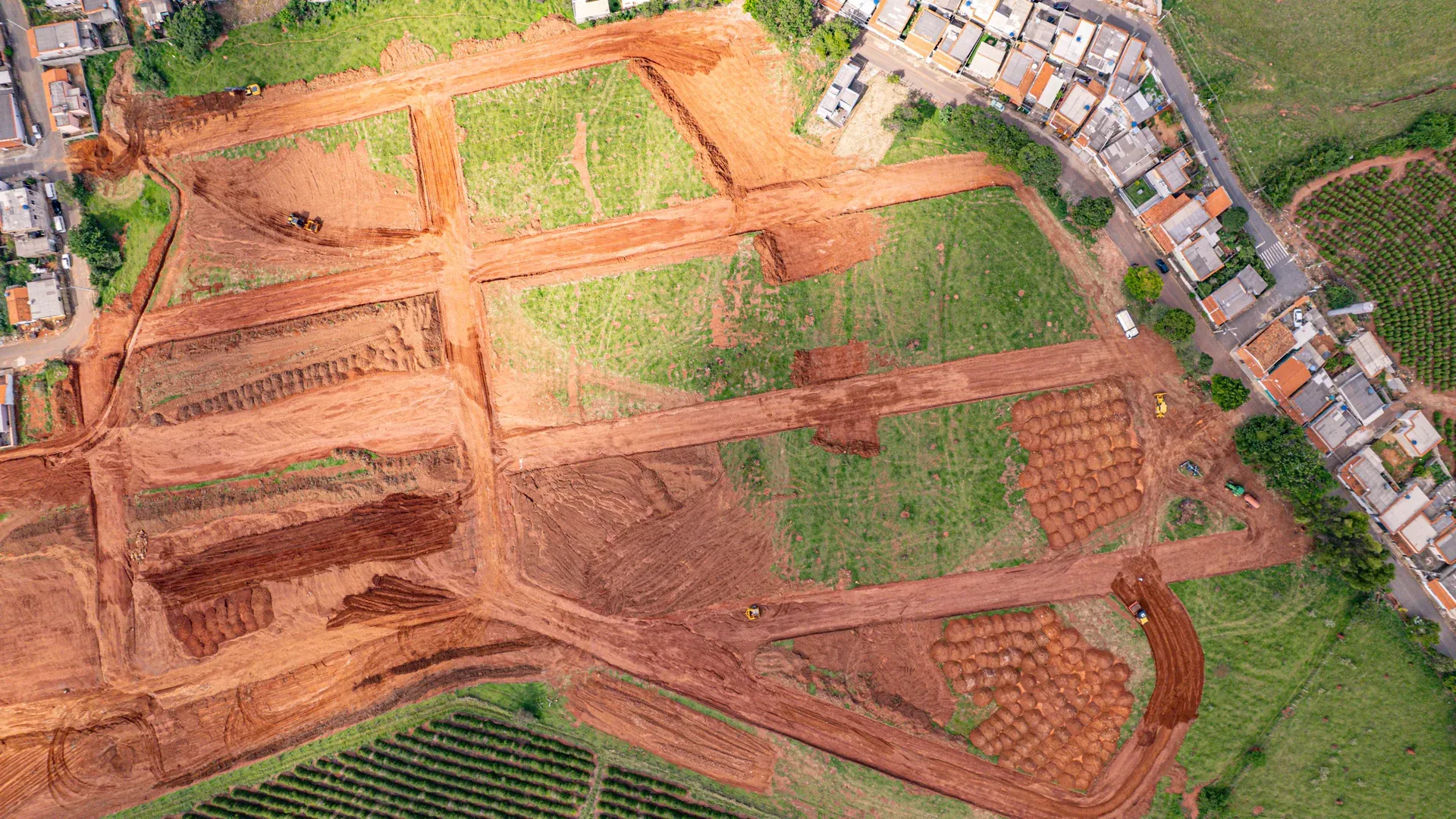 Vista aérea do conjunto do Ouro Verde com os lotes em terraplenagem e Cana Verde ao fundo